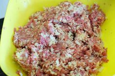 ground meat in a yellow bowl on a stove top with seasoning flakes around it