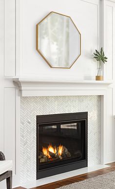 a white fireplace with a mirror above it