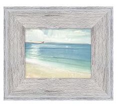 a white wooden frame with an ocean scene painted on the front and bottom, holding a painting of a boat in the water