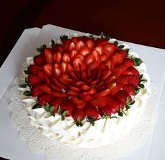 there is a cake with strawberries on the top and white frosting around it