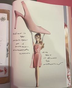 an open book with a drawing of a woman's high heeled shoe on it