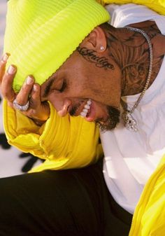 a man with tattoos on his head and yellow jacket