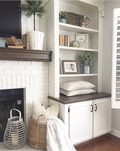 a white fireplace with bookshelves and shelves above it