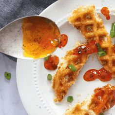 a white plate topped with waffles covered in sauce