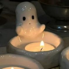 three lit candles with ghost faces in them