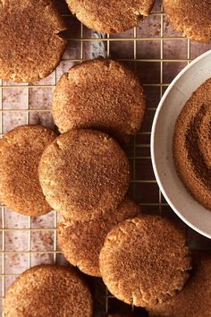 some cookies are on a cooling rack next to a bowl