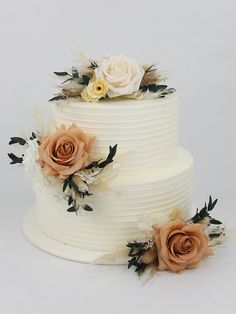 a three tiered cake with flowers on the top and bottom, sitting next to each other