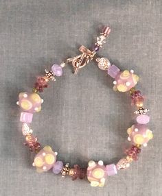 Quaint violet-themed bracelet with hues of pink and purple beads, using different shaped beads and silver beads as spacers and bead caps. This chunky but playful piece is a perfect choice for Mother's Day, Birthday, or any occasion to celebrate your closest friend. Length: 7.5 Inches Closure: Lobster claw ** If you like this adorable bracelet you might also like this one  https://www.etsy.com/listing/611039845/raspberry-parade-simple-purple-and-pink?ref=shop_home_active_2 Purple Drop Earrings, Beautiful Beaded Necklaces, Blue Beaded Bracelets, Diy Jewelry Inspiration, Memorial Bracelet, Jewelry Styles, Blue Beaded Necklace, Purple Beads, Bracelets Design