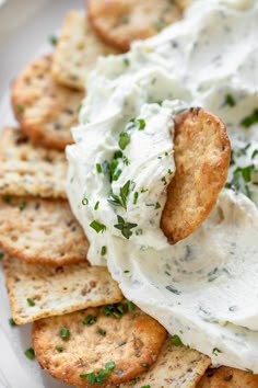 crackers with sour cream and parsley on them are arranged on a plate, ready to be eaten