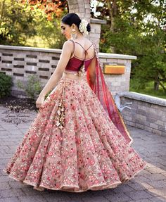 a woman in a pink and red lehenga