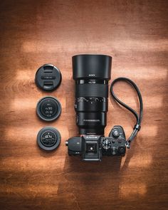 a camera lens sitting on top of a wooden table next to some other items and accessories