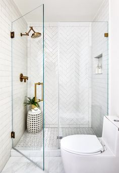 a bathroom with white tile and gold fixtures