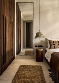 a bed sitting next to a mirror in a bedroom