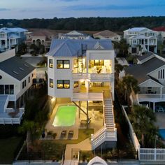 an aerial view of a house with a pool and lots of houses in the background