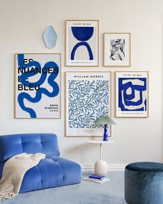 a living room with blue furniture and art on the wall