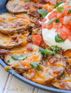 an omelet with bacon, tomatoes and sour cream in a blue skillet