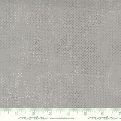 a gray fabric with white dots on it and a ruler in front of the fabric