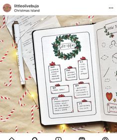 an open christmas planner on top of wrapping paper with candy canes and lights around it