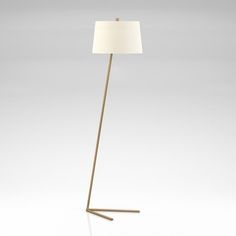 a floor lamp with a white shade on the top and a wooden stick underneath it