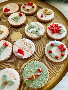 twelve decorated cookies on a tray with merry christmas words and wreaths in the middle