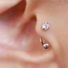 a close up view of a person's ear with a single diamond in the middle