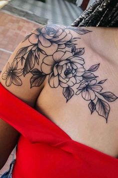 a woman wearing a red top with flowers on her chest and shoulder tattoo design in black ink