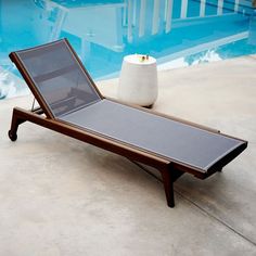 an empty chaise lounge next to a pool in the day time, with no one around it