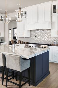 a large kitchen with white cabinets and marble counter tops, along with bar stools