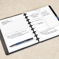 an open notebook with writing on it and a pen sitting next to the pages that are lined in