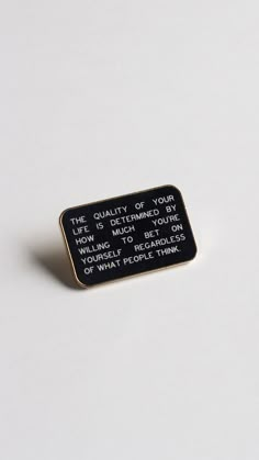 a black and white pin that says the quality of your life