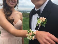 a man in a tuxedo and a woman in a dress hold flowers together