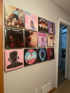 a wall with various records on it in front of an open door and a doorway