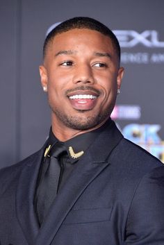 a man in a suit and tie smiling at the camera