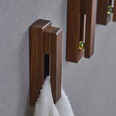 the towel rack is made from wood and has two towels hanging on it's sides