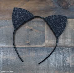 a black cat ears headband on top of a wooden table