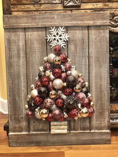 a christmas tree made out of old wood with ornaments on the top and below it