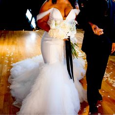 the bride and groom are walking down the dance floor at their wedding reception, dressed in black tuxedos