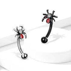 two black and red earrings on top of each other, one with a spider dangling from it's back