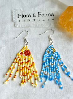 two pairs of beaded earrings are sitting next to each other