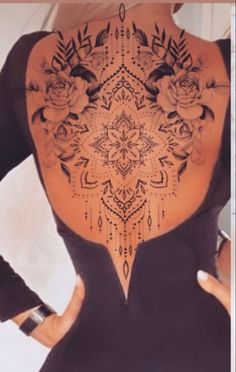 the back of a woman's body with tattoos on it