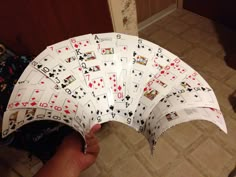 a hand holding several playing cards in it's palm, with the top half folded up