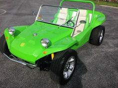 a green dune buggy is parked in a parking lot