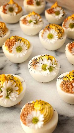 eggs decorated with flowers and seeds on a marble countertop, ready to be eaten