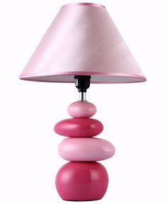 a pink lamp sitting on top of a table next to a white shade over it