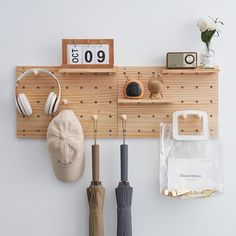 an umbrella, headphones, and other items are hanging on a coat rack with hooks