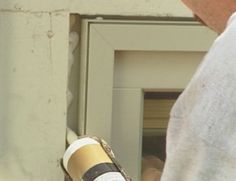 a person holding a wine bottle in front of a fire escape door with their hand on the handle