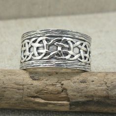 Celtic Scavaig Wedding Ring Continuous Celtic Weave Design on Sterling Silver Ring. 11 mm wide and stamped 10K & .925 (Sterling Silver). Oxidized background with bark edges. Available in whole and half sizes 5 to 13. (custom orders up to size 15) Nicely boxed with silver cloth. Ships in 3 to 5 days. Symbolic Wedding Jewelry With Intricate Design, Wedding Engraved Ring, Stamped 925, Wide Band, Traditional Band Jewelry As Gift, Symbolic Intricate Design Jewelry For Anniversary, Traditional Stamped 925 Engraved Wedding Ring, Ceremonial Engraved Round Band Jewelry, Handmade Silver Bands For Wedding, Unique Decorative Band Jewelry Gift, Heirloom Band Jewelry As Gift