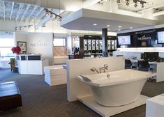 a large bathtub sitting in the middle of a room next to tables and chairs