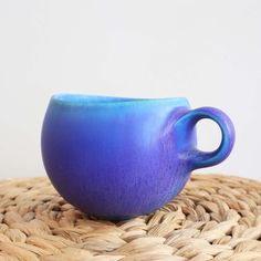 a blue cup sitting on top of a woven basket