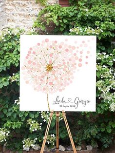 an easel with a wedding sign on it in front of some bushes and flowers